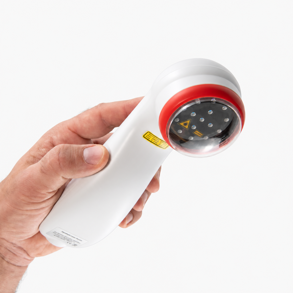 Handheld pet laser therapy device held in a hand, showing the laser diode head